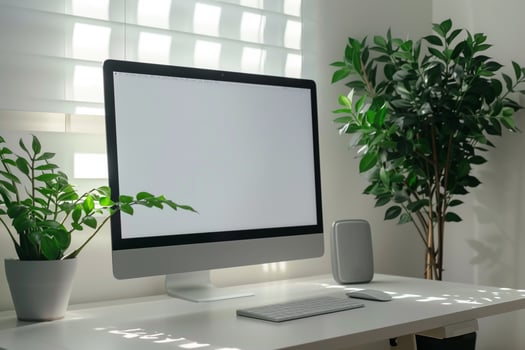 Computer mockup on a white desk with a plant in a space photo