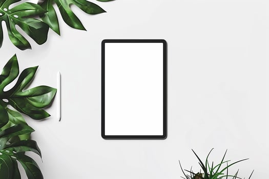 Tablet Positioned on a White Desk with Green Plant and Office Decor photo