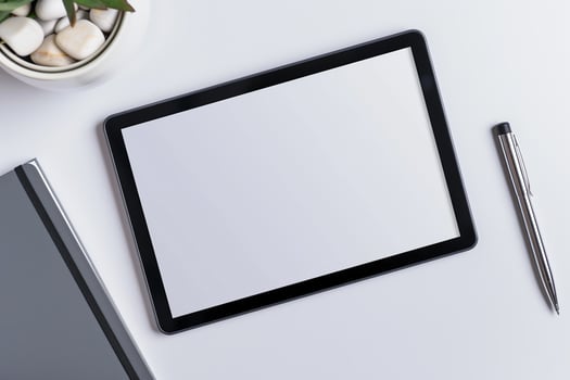 Tablet on Desk with Pen and Notepad Background photo