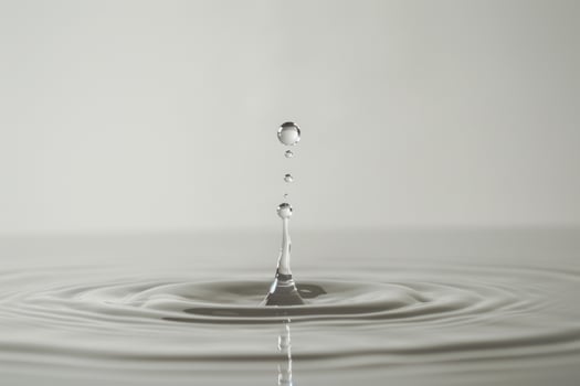 Single Water Droplet Creating Ripples in a Pool of Water with High Speed Capture photo