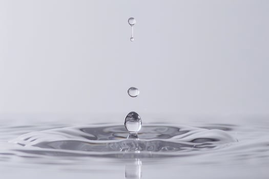 Single Water Droplet Creating Ripples in a Tranquil Pool of Water photo