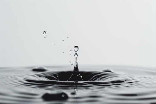 Single Water Droplet Falling into a Calm Pool Creating a Ripple Effect photo