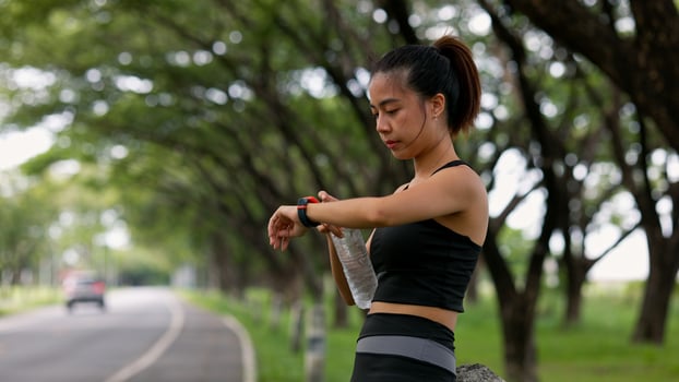 A woman is standing in a park, wearing a black tank top photo