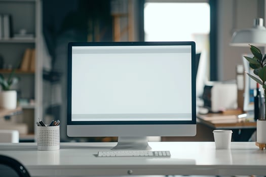 Computer Mockup on White Desk Surrounded by Marketing Materials photo