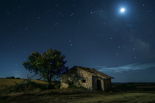 Rustic Farmhouse with Full Moon and Starry Night Sky photo
