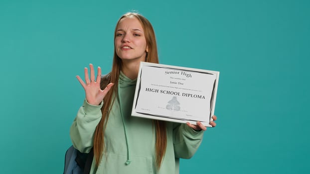 Cheerful teenager holding school award, excited after receiving accreditation for passing classes. Jolly person grateful for received honor, isolated over studio background, camera A photo