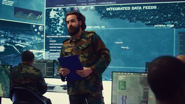 Army general manages and interprets satellite footage to gain insight targeting enemy positions. Marine corps officer takes notes about hostile vessels trajectory, national safety. Camera B. photo