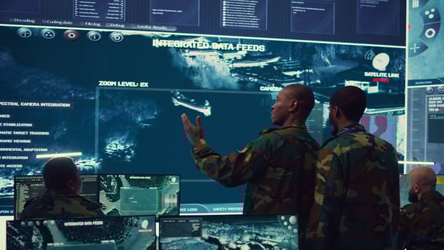 High ranking military personnel briefs the crew for a new federal mission, showing CCTV footage of satellite radar target ships for reconnaissance. Army officers provide intelligence. Camera B. photo