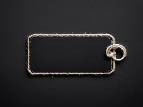 Black Paper Price Label With String Isolated on black background. photo