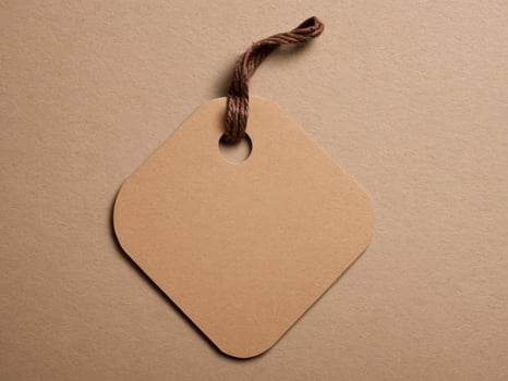 Brown Paper Price Tag With String Isolated on brown background. photo