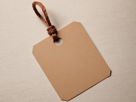 Brown Paper Price Tag With String Isolated on brown background. photo