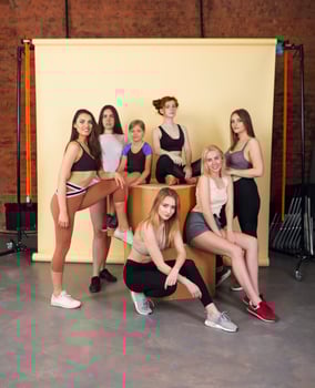Happy different race women wearing sports top and leggings looks perfect and gathered at fitness studio for training together. Body positive concept photo