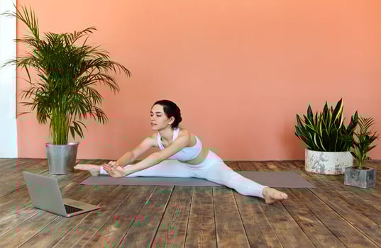 Young woman having online yoga session at home photo