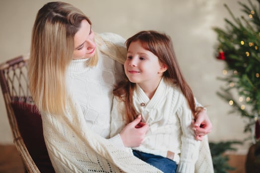Happy playful little girl daughter playing with positive mother, jumping on sofa, spending time together during Christmas holidays at home photo