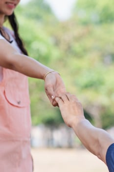 A young man is holding the hand of a young woman who is his lover to express his love and promise to love and care for each other forever. The concept of friendship, love and kindness photo