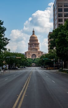View along Congress Avenue to the entrance and dome of the Texas State Capitol with empty street photo