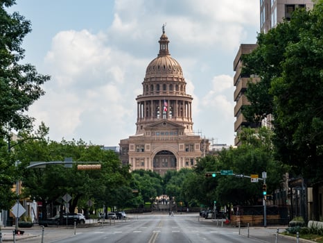 View along Congress Avenue to the entrance and dome of the Texas State Capitol with empty street photo