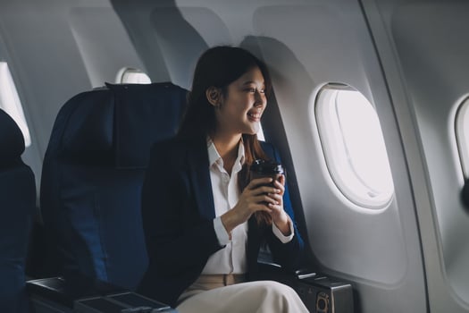 Asian woman sitting in a seat in airplane and looking out the window going on a trip vacation travel concept.Capture the allure of wanderlust with this stunning image photo