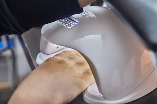 Hand Under UV Lamp for Gel Manicure photo