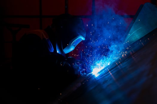 Skillful metal worker working with arc welding machine in factory while wearing safety equipment Metalwork manufacturing and construction maintenance service by manual skill labor concept photo
