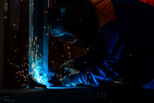 Skillful metal worker working with arc welding machine in factory while wearing safety equipment Metalwork manufacturing and construction maintenance service by manual skill labor concept photo