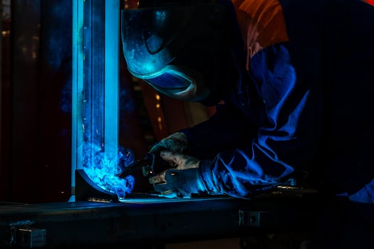 Skillful metal worker working with arc welding machine in factory while wearing safety equipment Metalwork manufacturing and construction maintenance service by manual skill labor concept photo