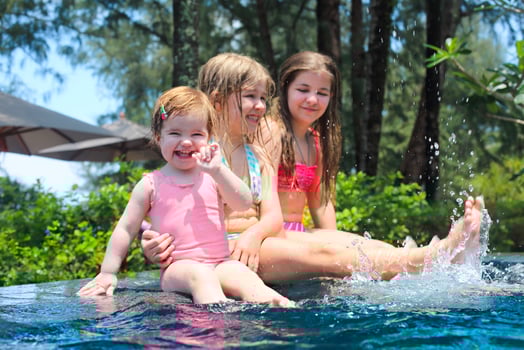 Three cute girls playing in swimming pool photo