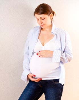 Pregnant woman touching belly gently photo