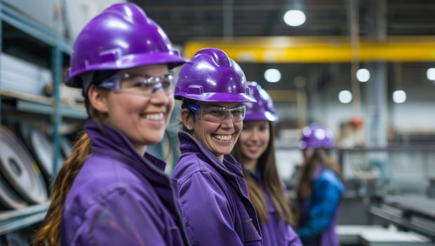 A team of smiling female workers in purple safety helmets and gear pose together confidently.Generated image photo