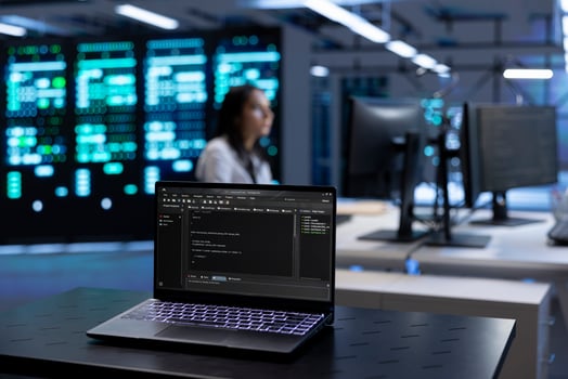 Focus on laptop in front of data center workers looking for firewall misconfigurations affecting servers. Close up on notebook used by system administrators in server room photo