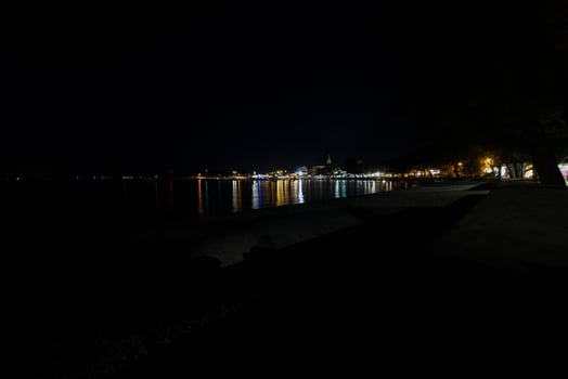 Night picture over the beach and the illuminated town of Fazana in Istria photo