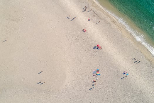 overhead aerial view of a beach with people and umbrellas photo
