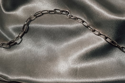Golden chain decoration on golden silk fabric with space for text photo