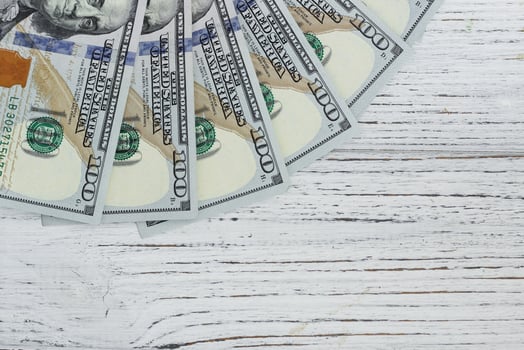 Bills of 100 dollars on a wooden background photo