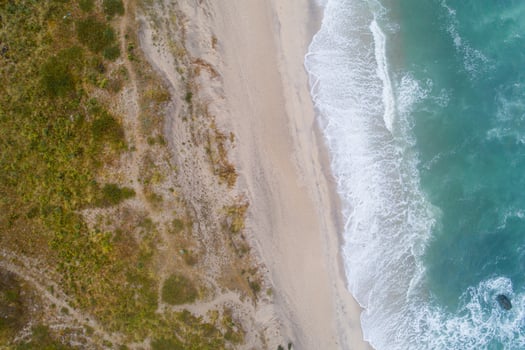 Aerial top view of beautiful tropical white sand beach with wave foam and transparent sea, Summer vacation and Travel background with copy space, Top view from drone photo