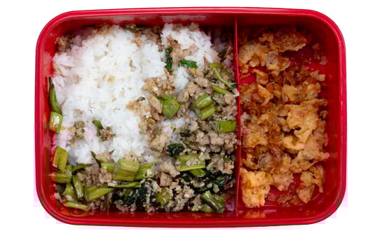 Bright red plastic lunch box with food compartments. Food of Stir-fried minced pork with basil mixed with Morning glory and cut into pieces. Divide in half of Stir-fried Preserved Radish with Egg. photo
