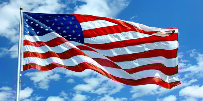 Waving American Flag Against Blue Sky on Independence Day photo