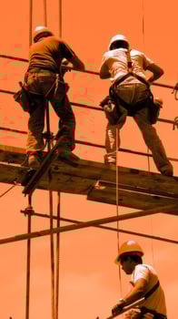 Construction workers on scaffolding with safety harnesses photo
