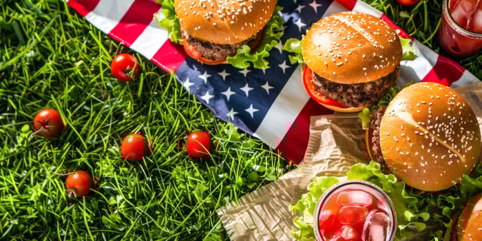 Delicious burgers and cold drinks on grass with USA flag photo