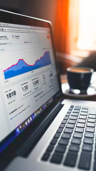 Analytical data on a laptop screen with a coffee cup photo