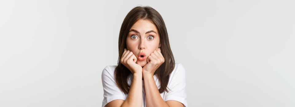 Close-up of intrigued young gossiping girl, leaning on hands and looking wondered at camera, gasping impressed, white background photo
