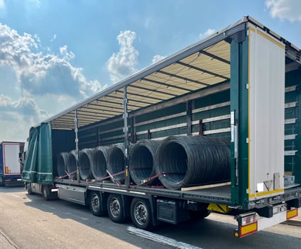 An open semi-trailer truck carrying metal wire. Industrial logistics and transportation of goods photo