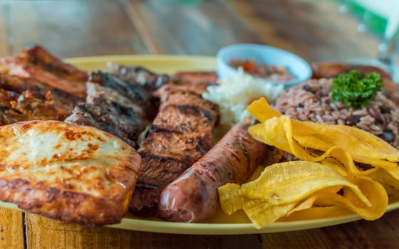 Variety of fried and grilled meats served on wooden table. Traditional Nicaraguan bay horse served on the table. Variety of food meats and assortment of sausages photo