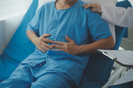 Hospitalized man lying in bed while doctor checking his pulse. Female physician examining male patient in hospital room. photo