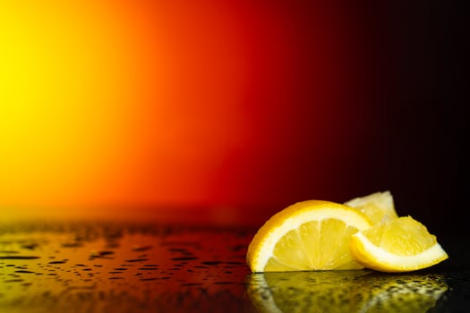 Slices of yellow lemon on a black wet surface. Water drops on a smooth table. photo