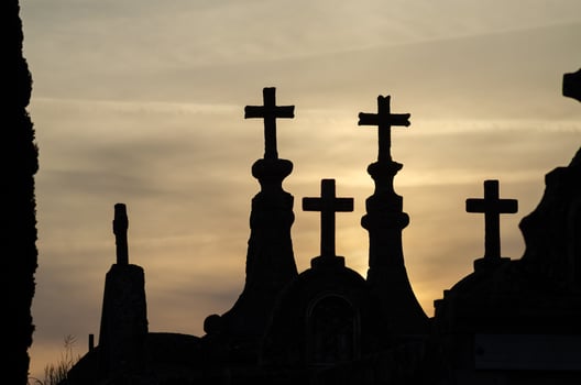 Silhouette of tomb crosses in a christian cemetery at sunset. Death concept photo