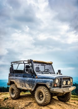 Dirty SUV on blue sky background. An open-top car for off-road travel. photo