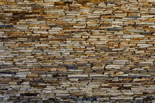 Wall of stone slate. Pattern of decorative slate stone wall surface. A wall of natural flat stones. Texture for background. Many slate tiles on a wall creating an interresting texture. photo