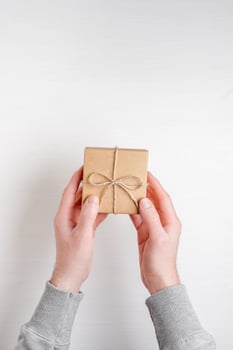 man's hands holds a gift in a box on a white background photo
