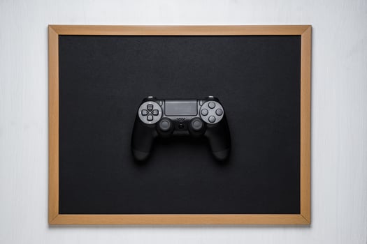 modern black wireless gamepad on a black chalk board in a frame on a white background photo